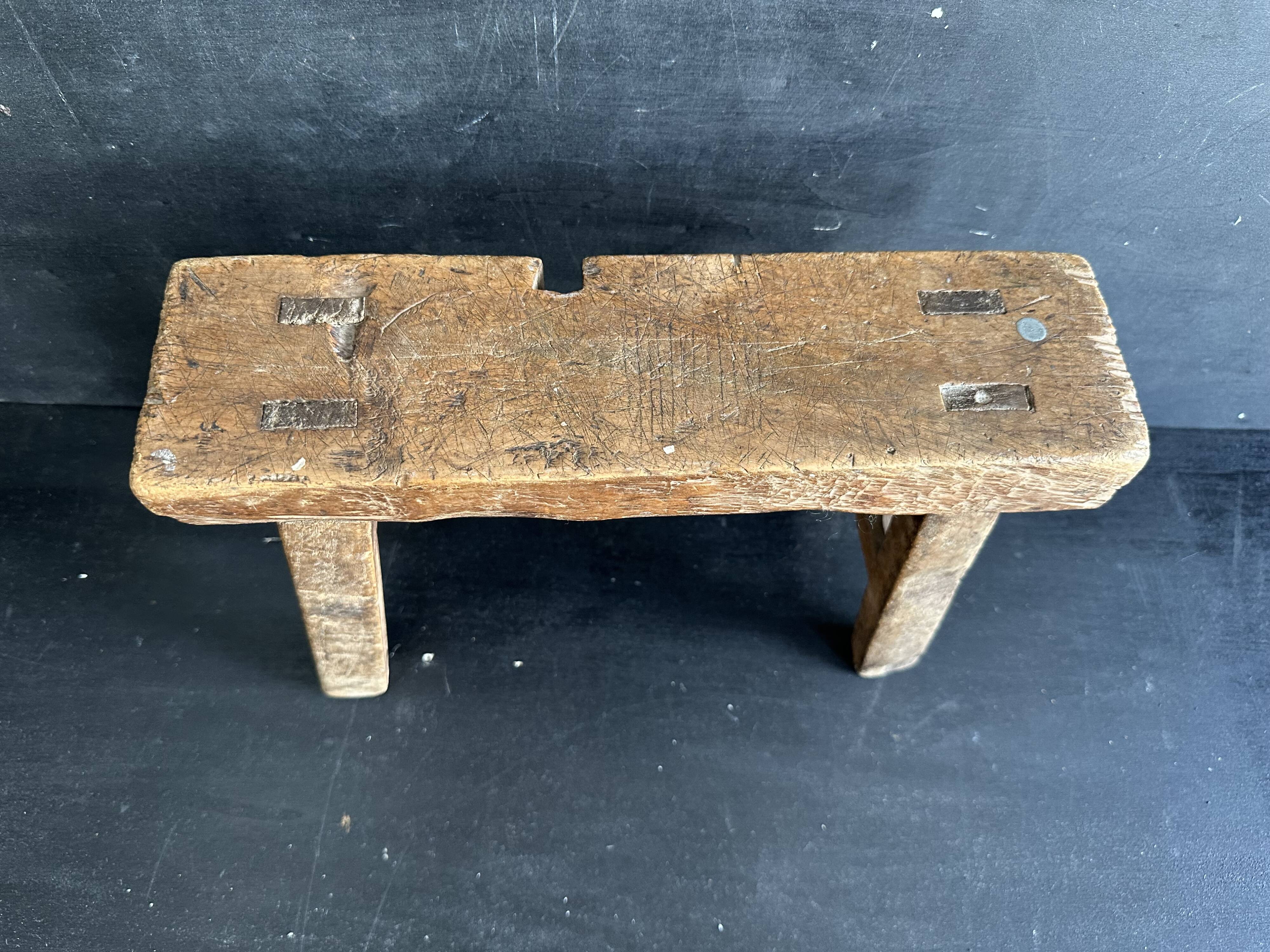 Ancient Chinese farm bench in patinated wood, small rustic stool.
