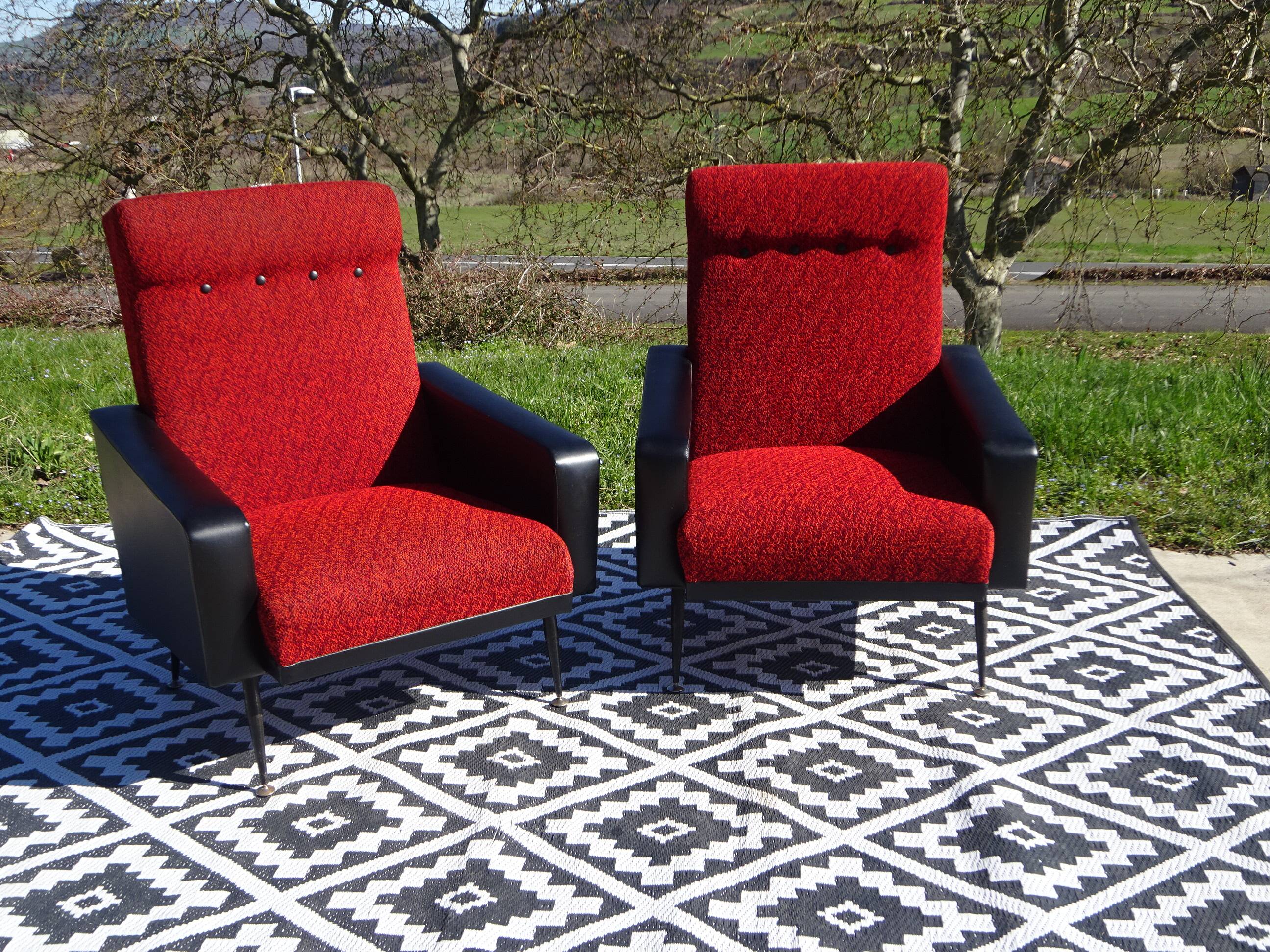 Vintage armchairs in red and black faux leather, the pair.