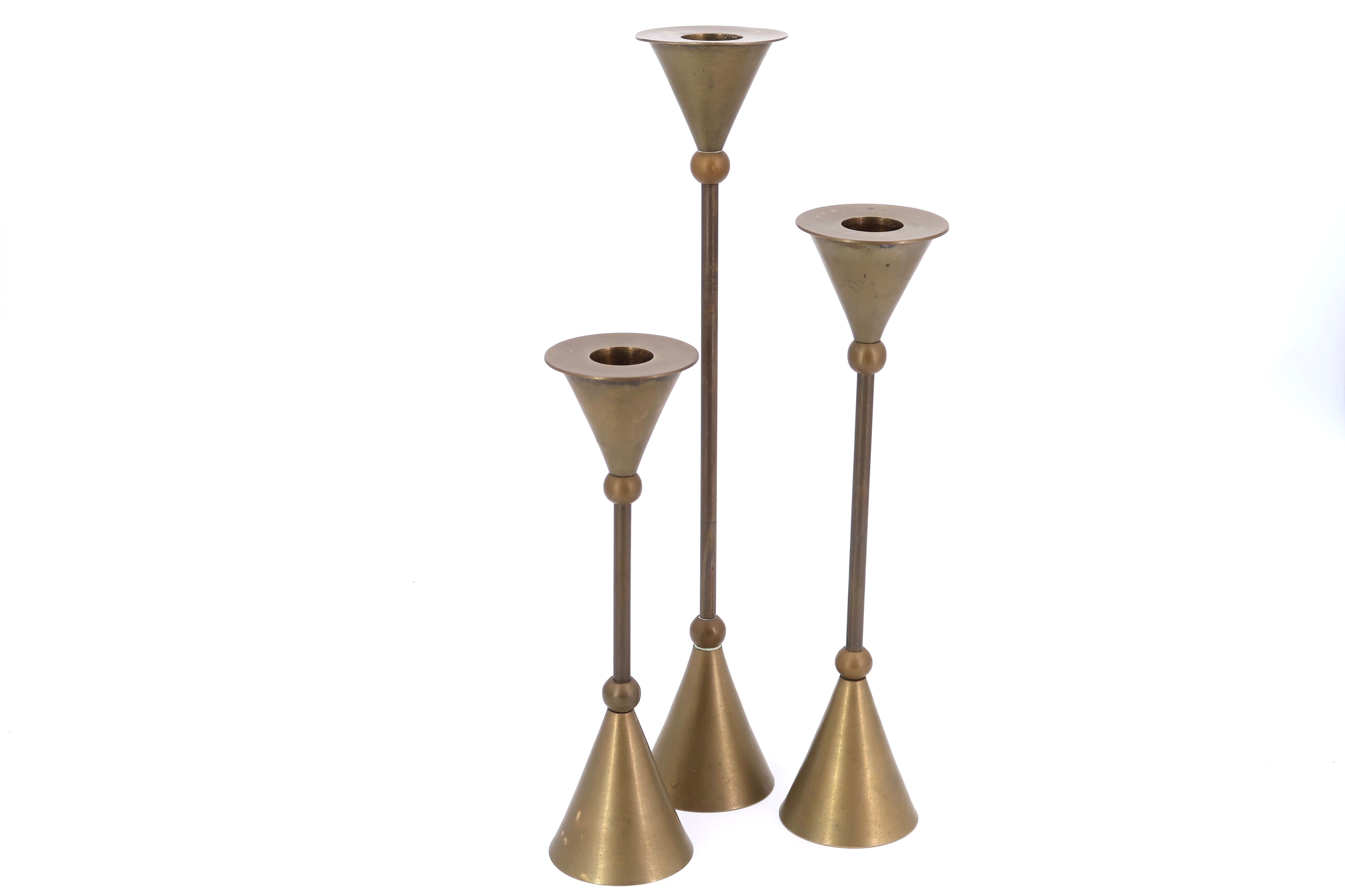 Trio of brass candlesticks by Christian de Beaumont