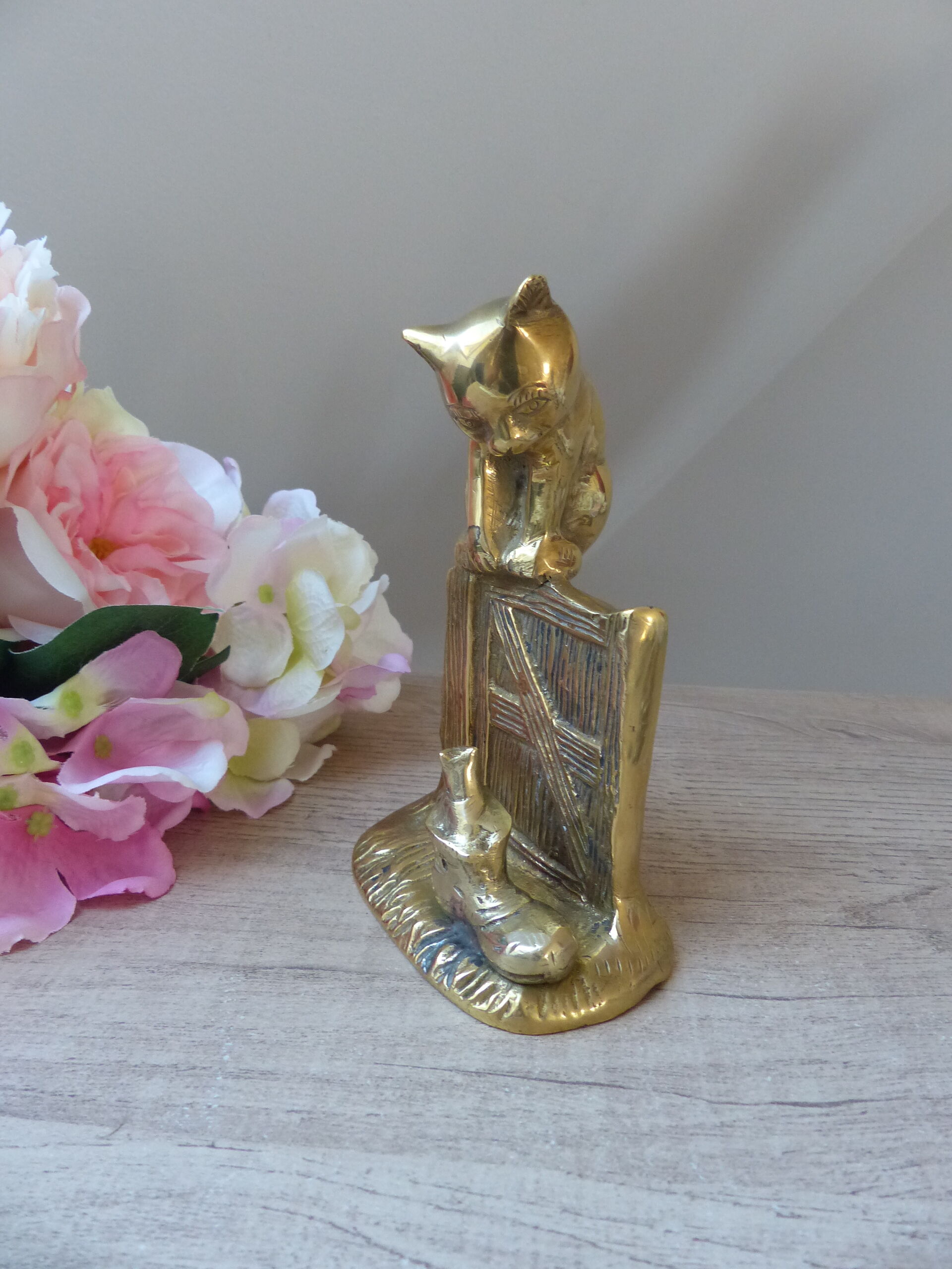 Golden brass cat figurine on fence looking at a mouse in a Vintage India shoe