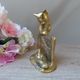 Golden brass cat figurine on fence looking at a mouse in a Vintage India shoe