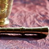 Mortar and its brass pestle with oriental gold and silver motifs