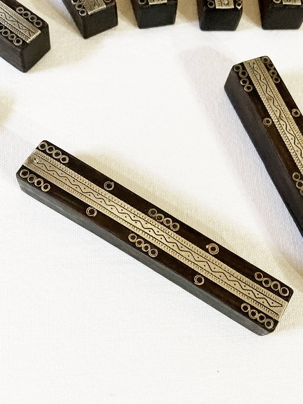 Set of 11 ebony wood knife rests with brass inlay