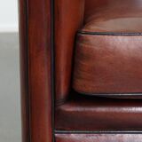 Sheepskin club armchair in a warm deep colour finished with black piping