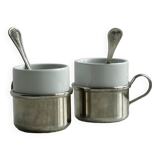 2 porcelain cups with metal supports and small spoons.