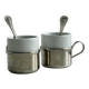 2 tasses en porcelaine avec supports en métal et petites cuillères.