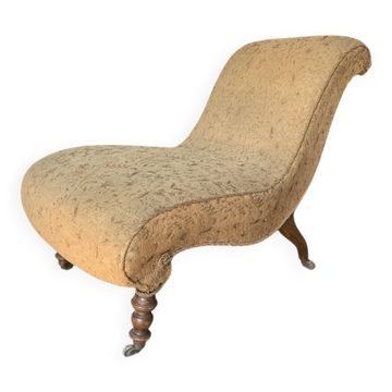 Fauteuil recamier ancien en tissu et bois, silhouette en S et pieds tournés.