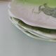 4 hand-decorated earthenware plates with vegetable and green leaf designs.