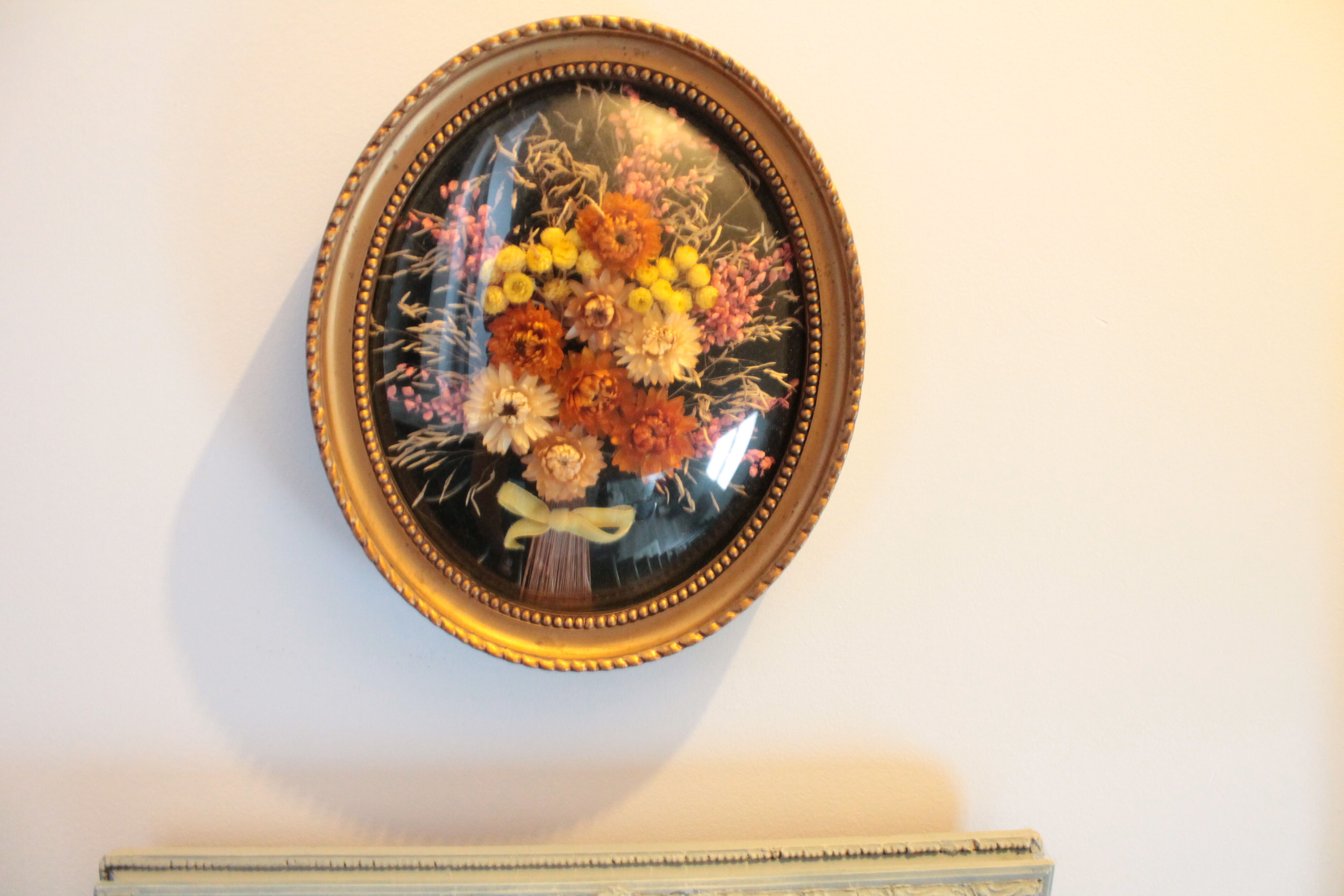 Golden vintage frame with bouquet of dried flowers under globe, wedding bouquet,