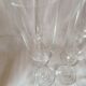 4 crystal champagne flutes with feet decorated with two knots.