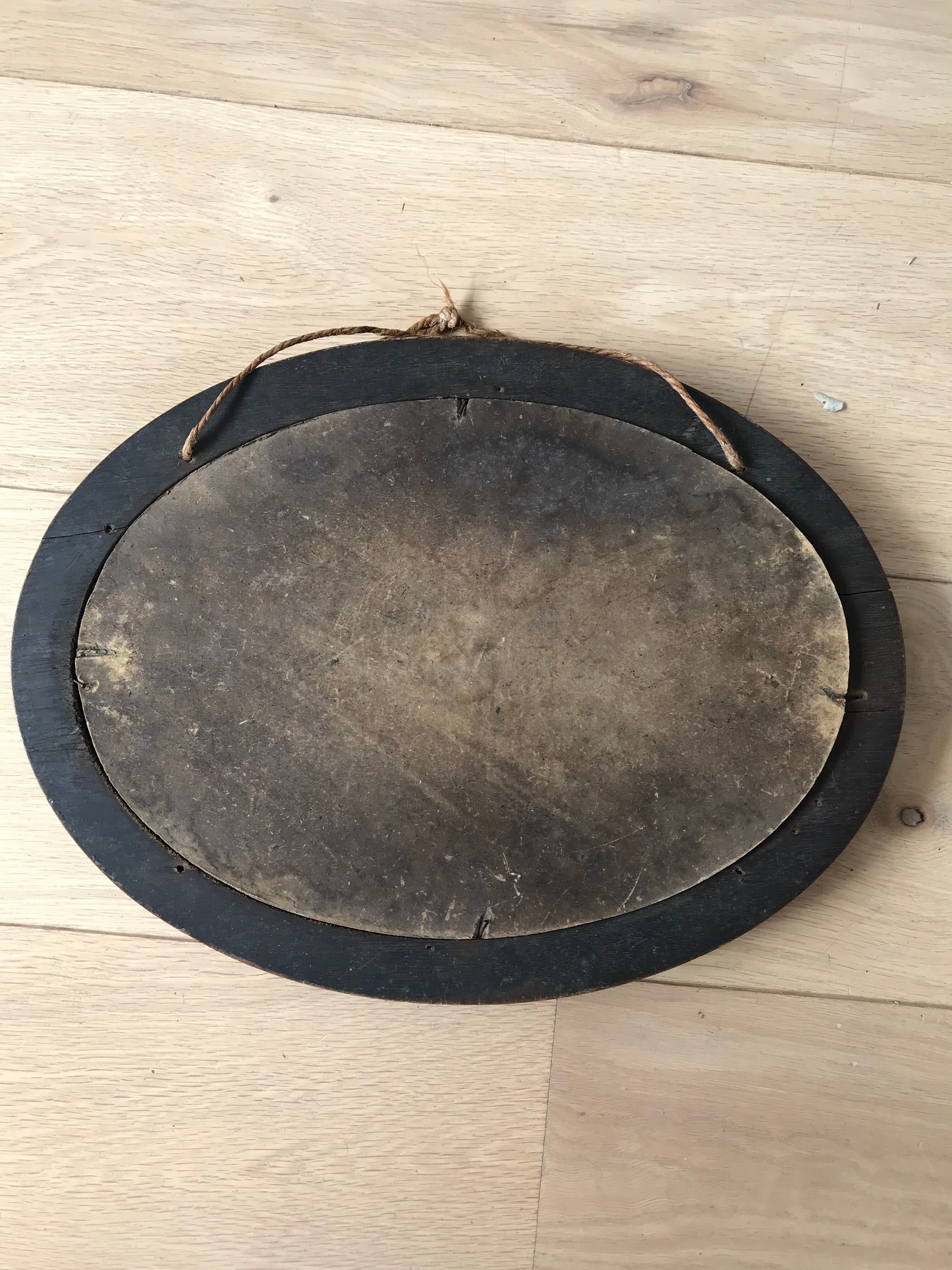 Old oval mirror with wooden frame