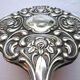 Face à main art nouveau miroir dans armature argent repoussé décor de roses 14x27cm