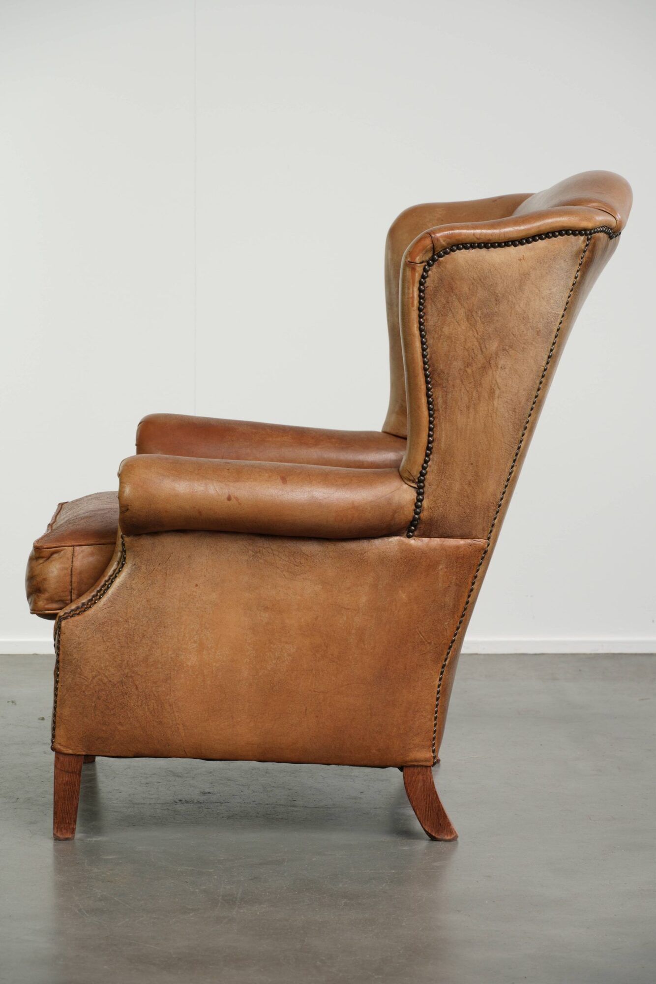 Sheepskin wingback armchair in a light cognac colour in English style
