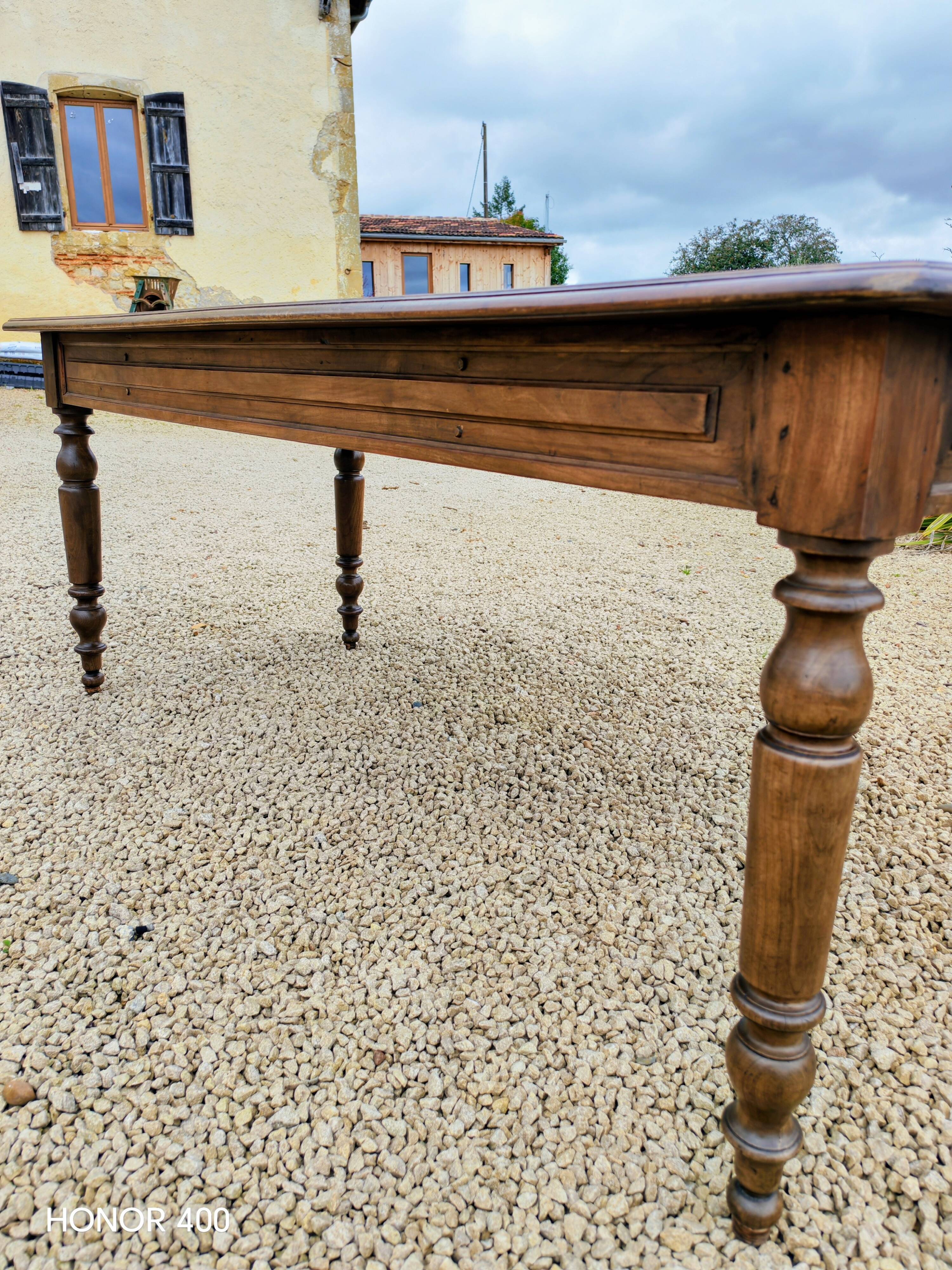 Old French farmhouse table in walnut with turned legs.