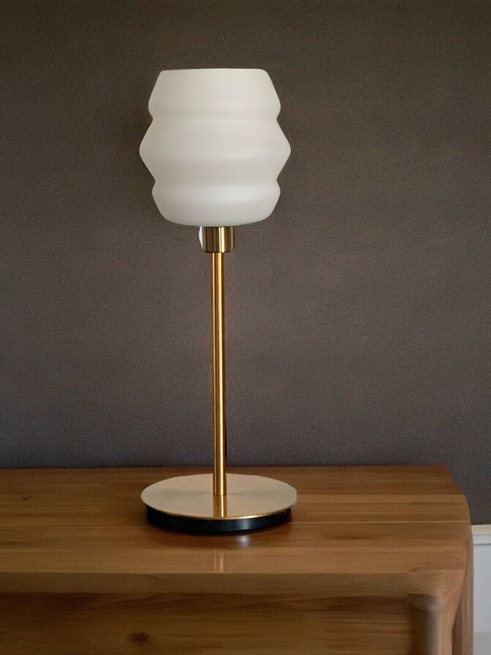 Table lamp with a vintage white glass globe and a golden base