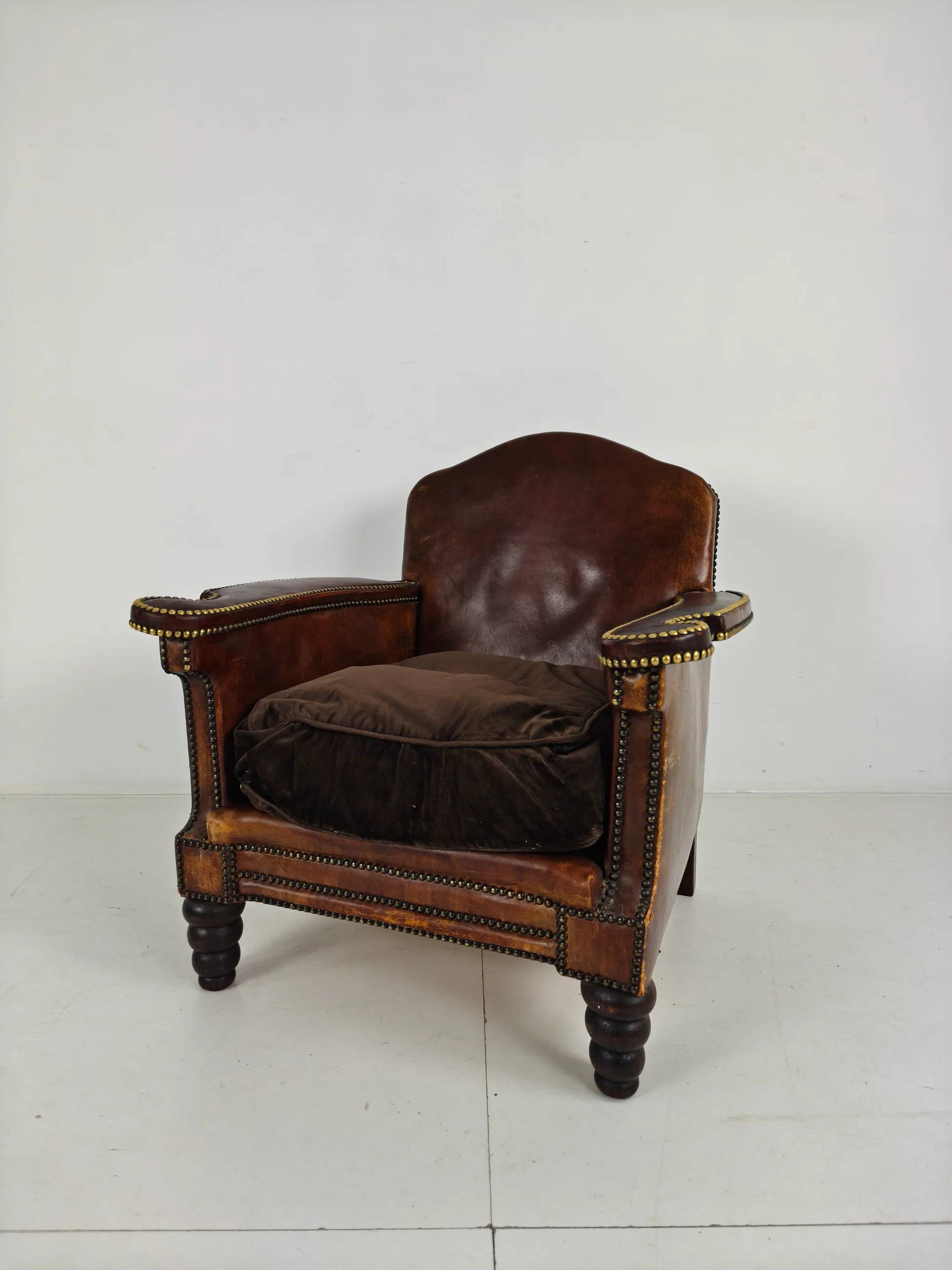 Antique leather club chair with stud detailing