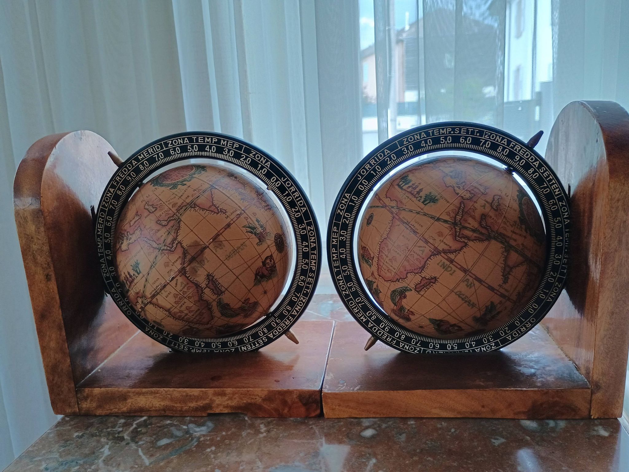 Pair of vintage bookends with rotating terrestrial globes on wooden bases in Spain