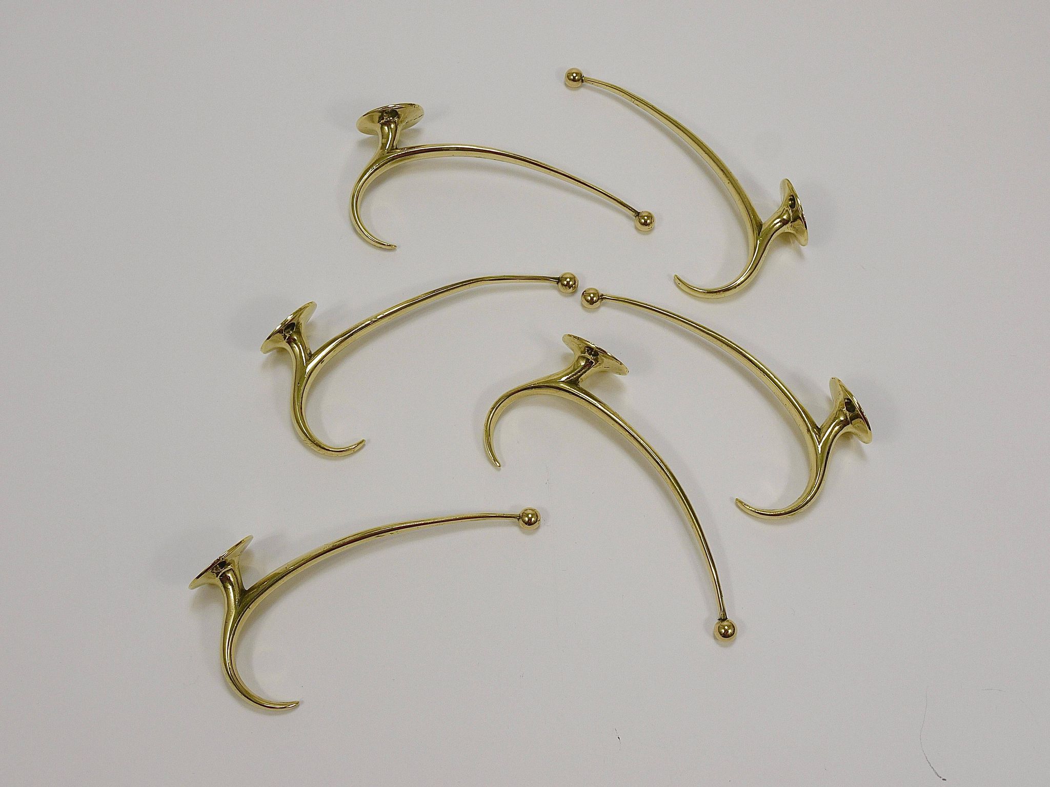 Two curved wall coat racks in brass by Franz Hagenauer, Vienna, mid-20th century, 1950s.