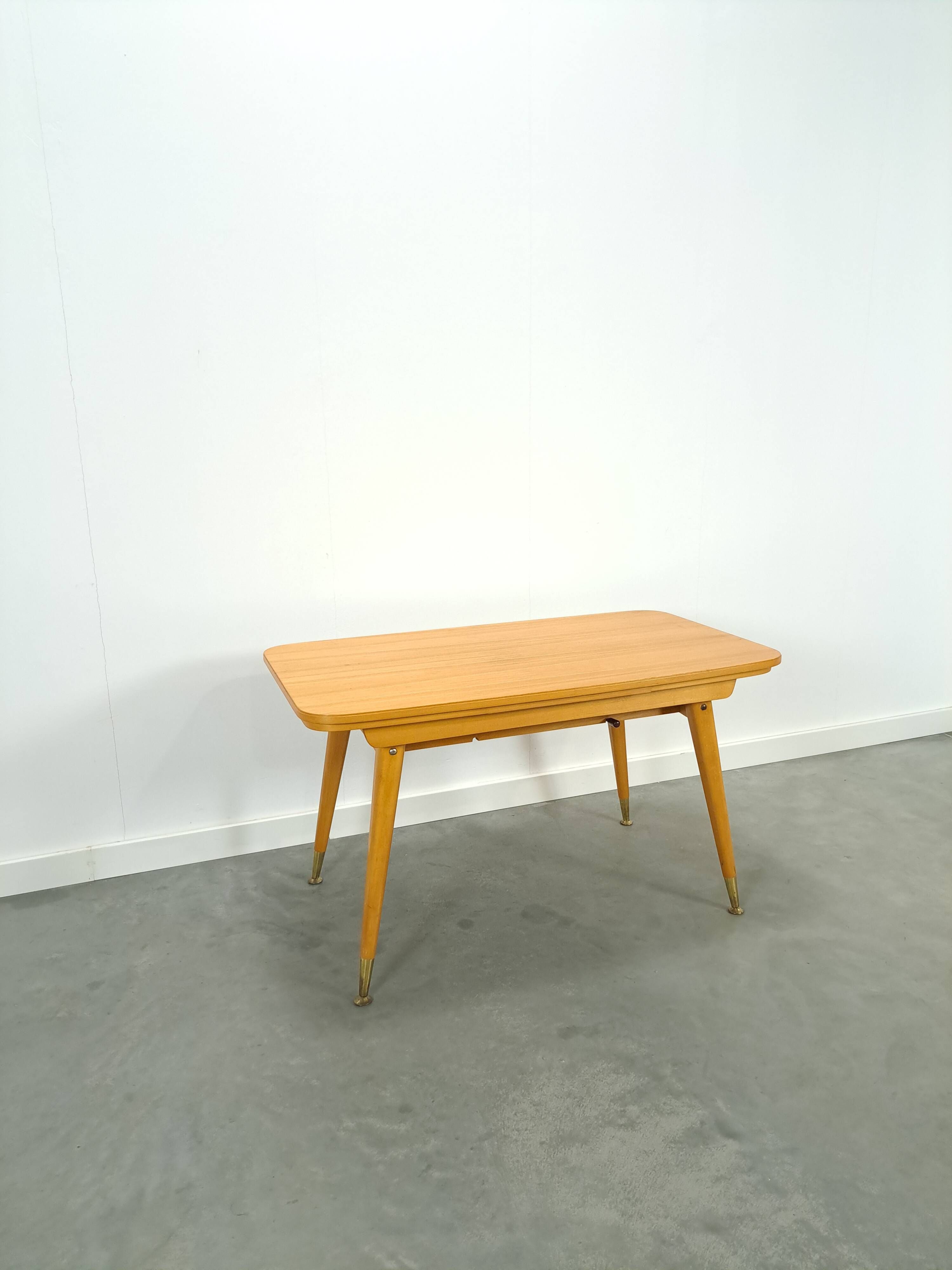 Vintage veneer table with pretty angular legs and brass at the base of the legs.