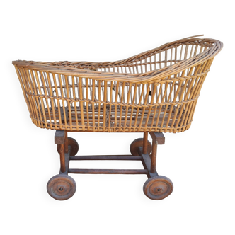 Old rattan cradle on wheels