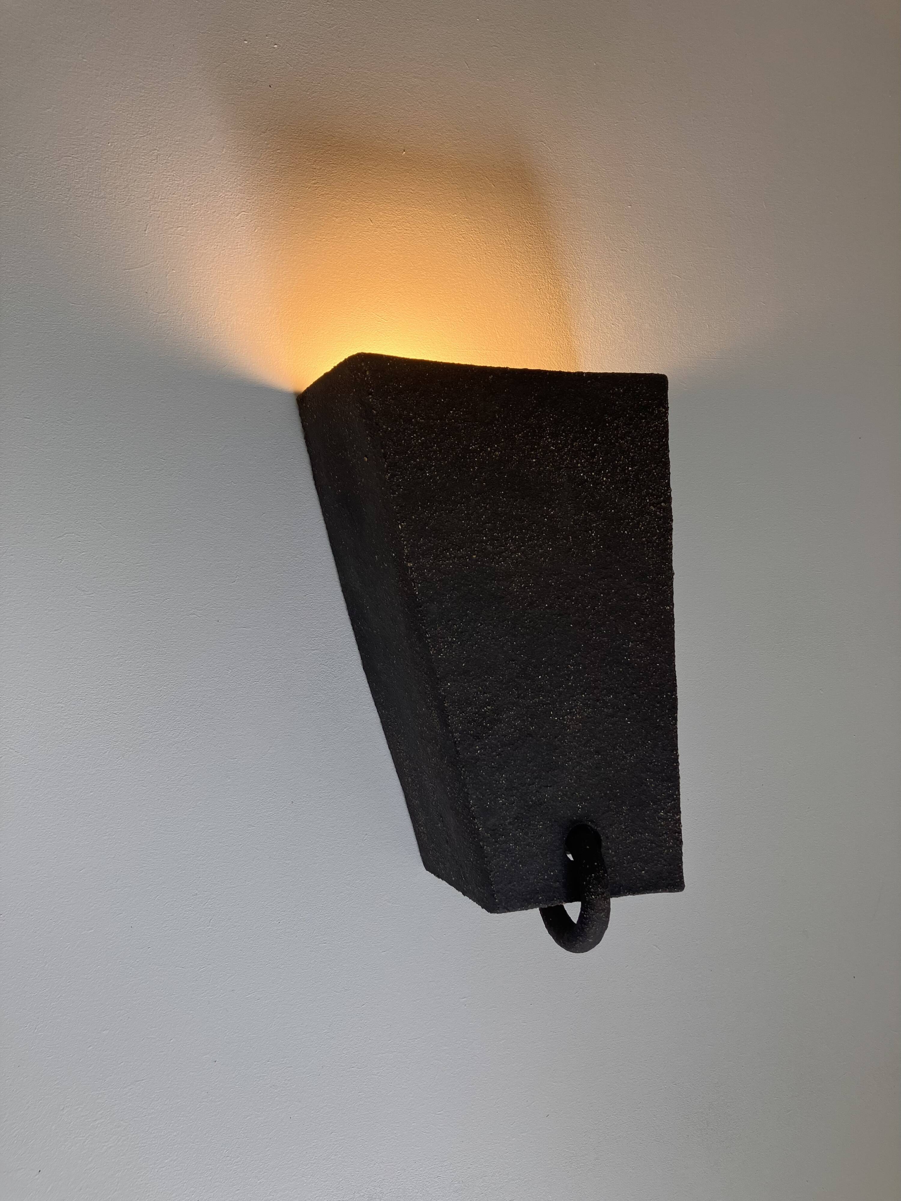 Graphical black stoneware ceramic wall light with handmade ring.