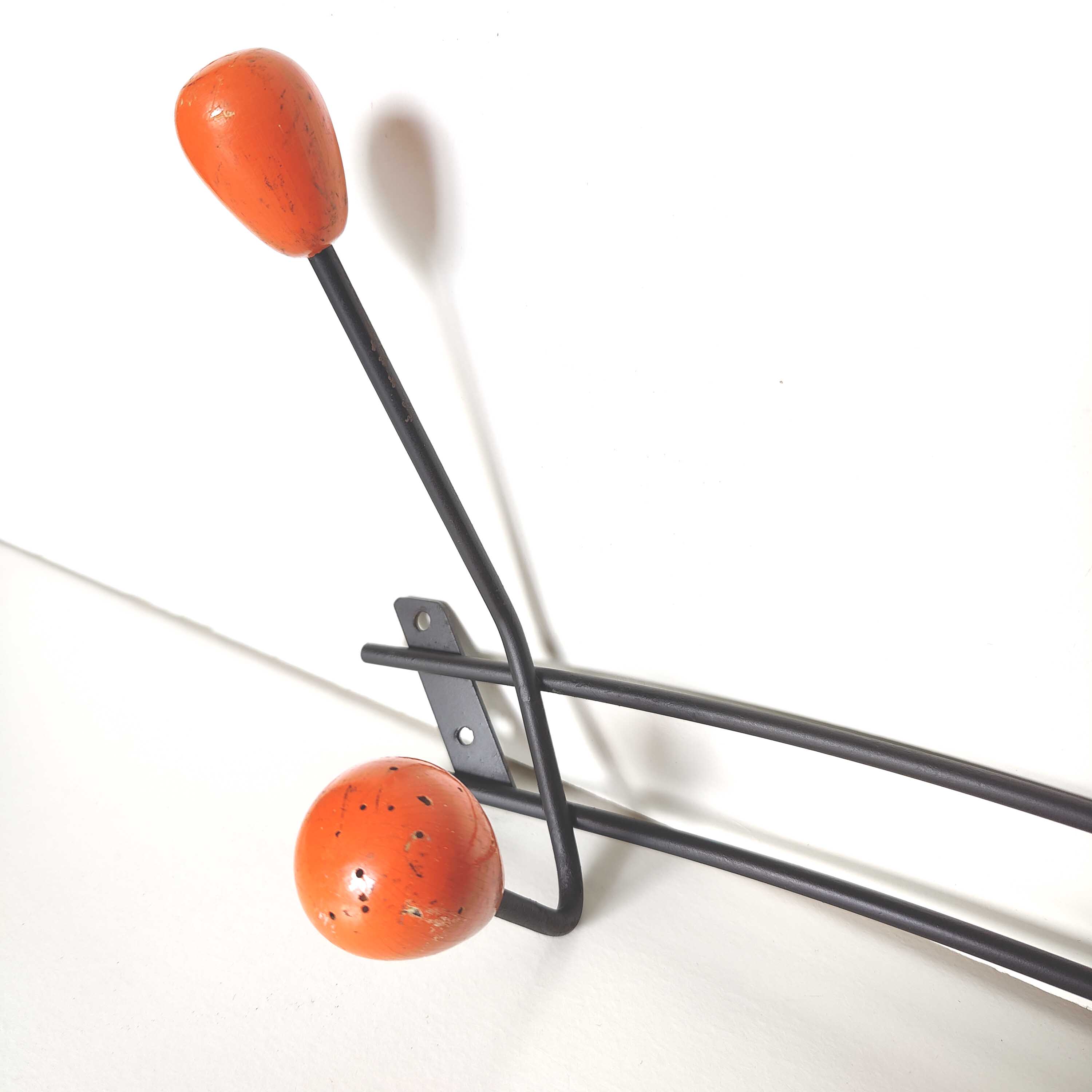Black metal coat rack and orange wood balls