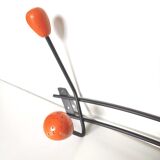 Black metal coat rack and orange wood balls