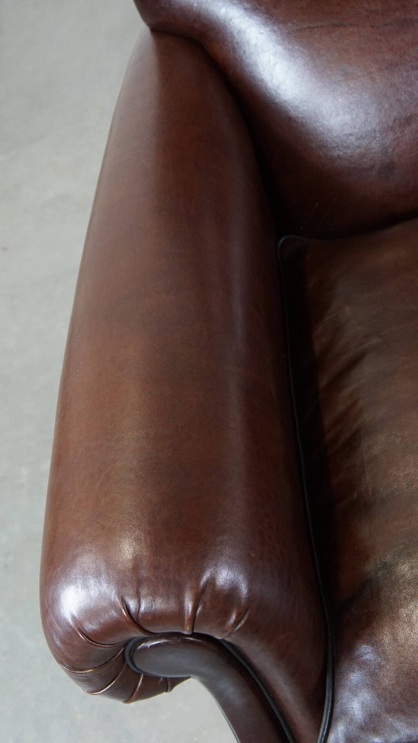 Comfortable and correct dark antique sheepskin English armchair in very good condition