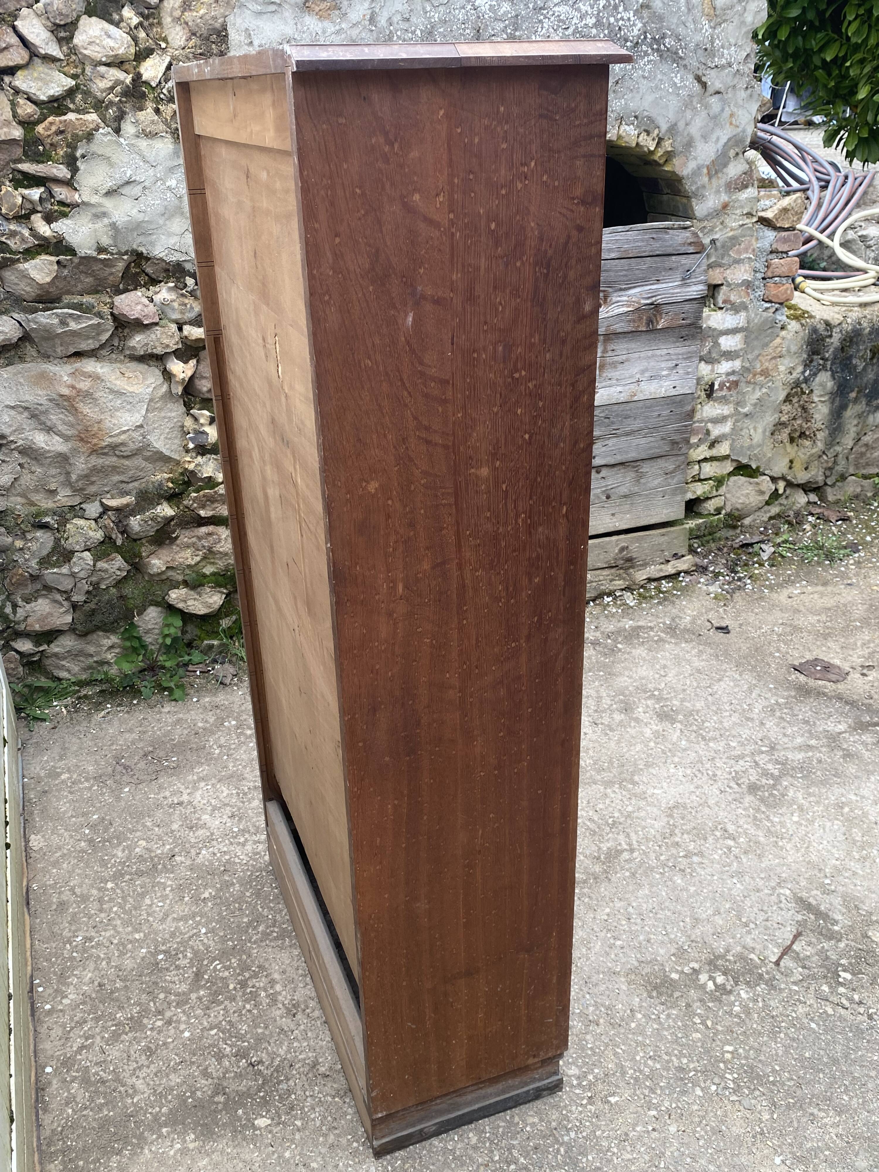 Oak two-column filing cabinet with curtains.