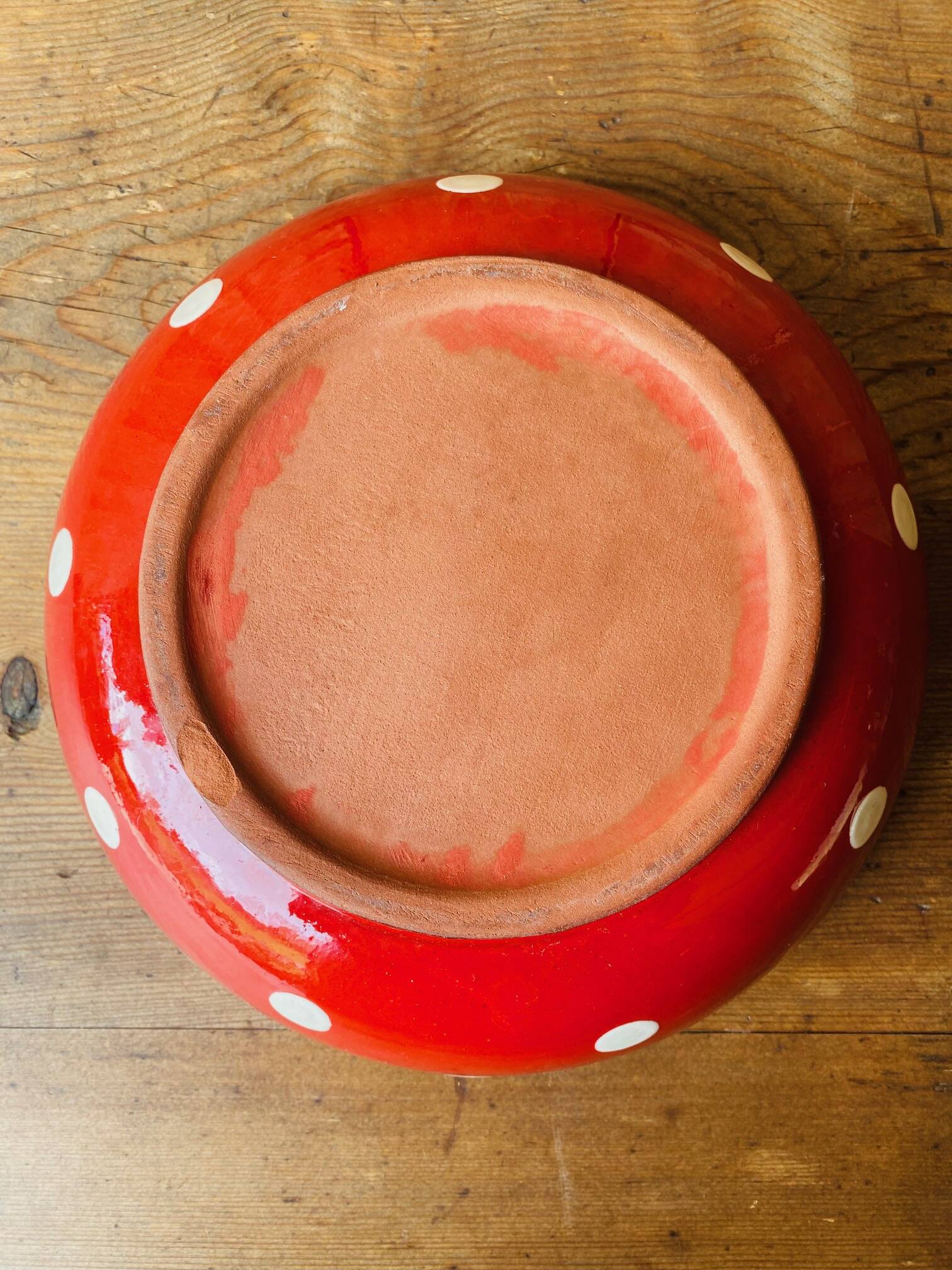 Ceramic salad bowl in red with white polka dots.
