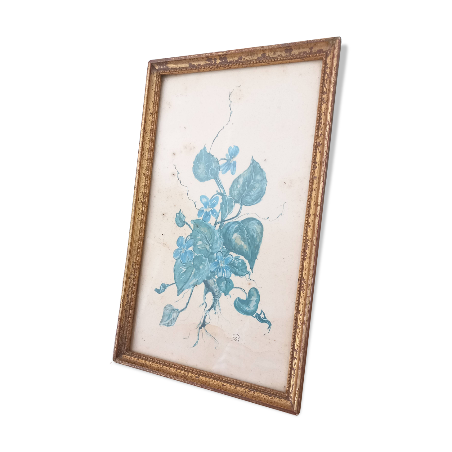 Decorative table with vintage blue flowers in a golden frame.