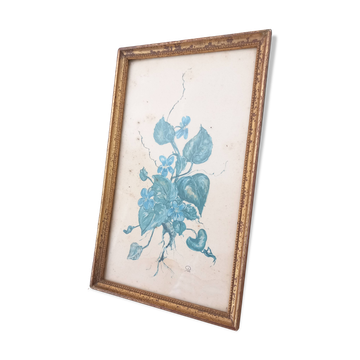 Decorative table with vintage blue flowers in a golden frame.