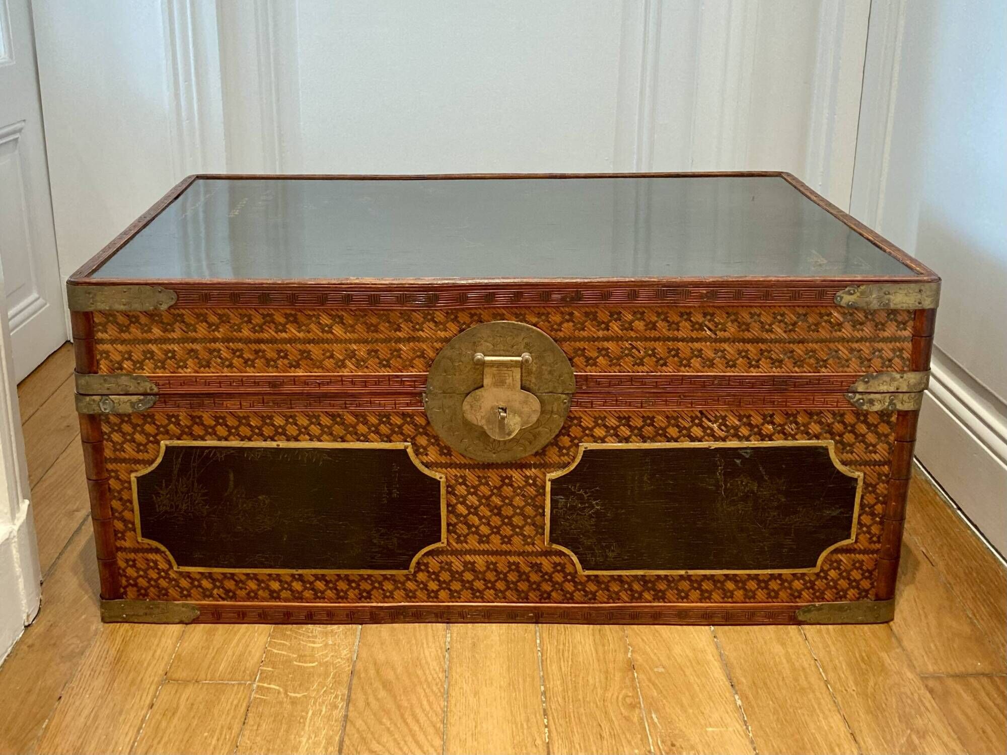 Beautiful vintage Chinese trunk in wicker, black and gold lacquered wood, and brass.