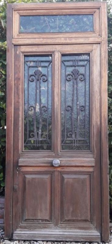 Oak entrance door and its frame and transom, wrought iron gates
