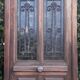 Oak entrance door and its frame and transom, wrought iron gates