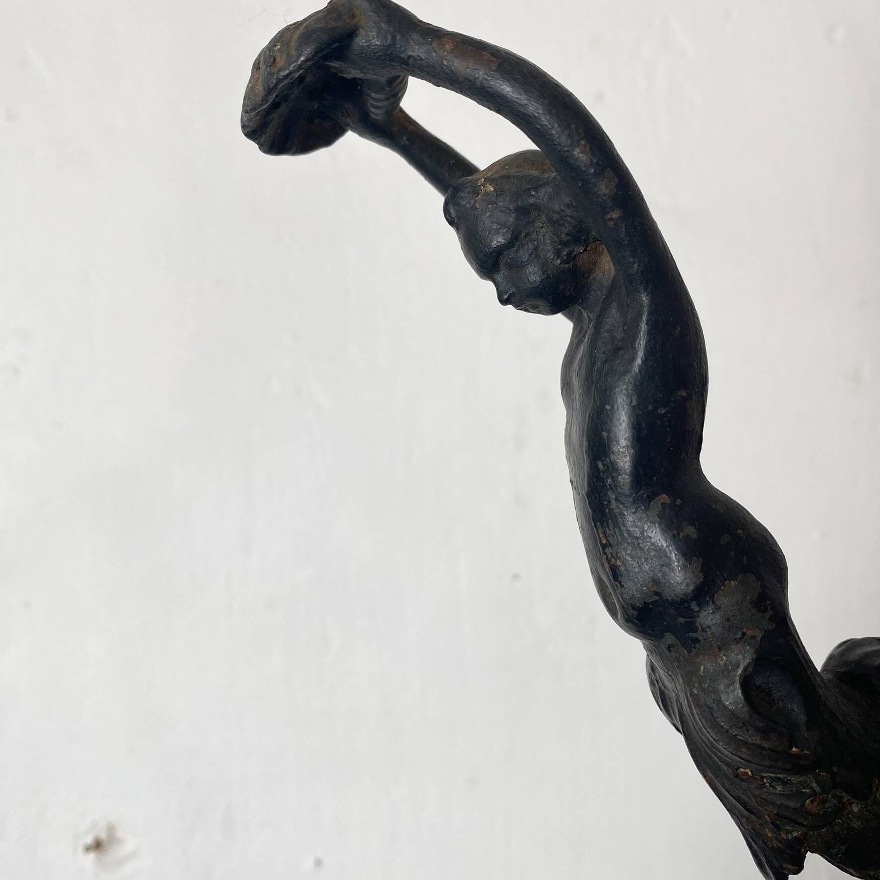 Antique cast iron coat hook with swimmer and shell basin.