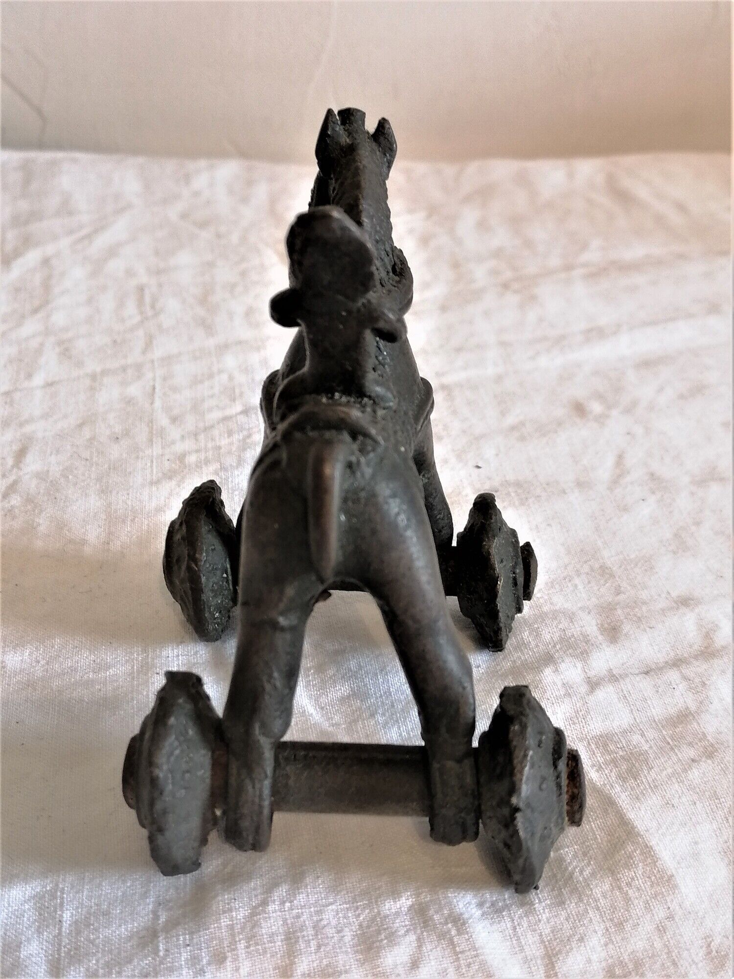 Old child's toy. Horse with bronze wheels. Ethnic object.