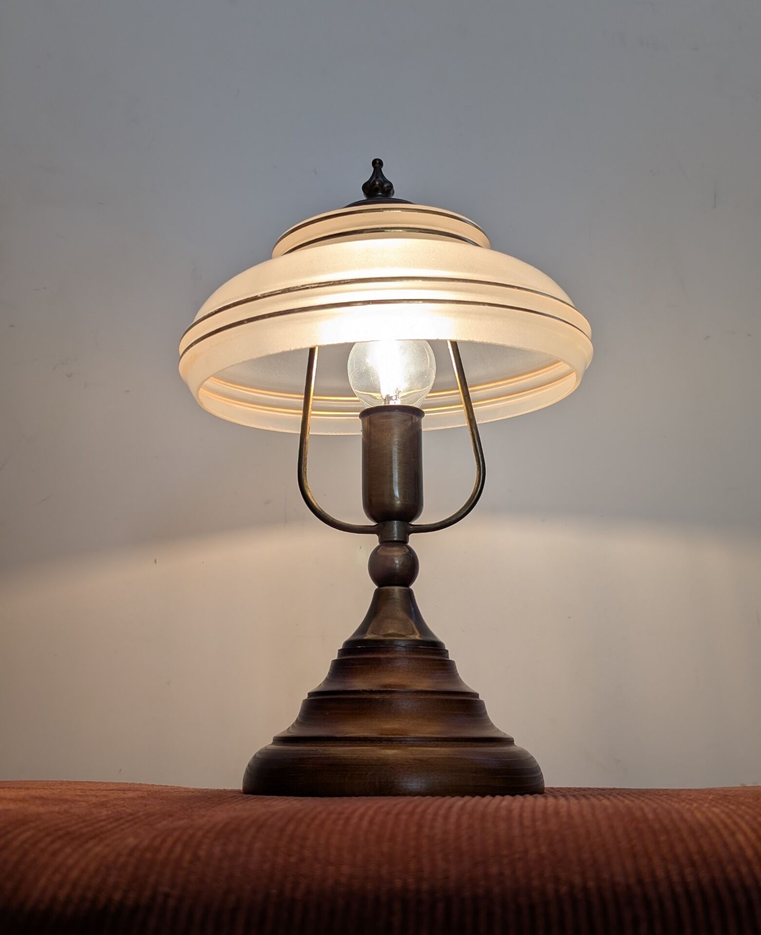 Vintage lamp made of turned wood, brass, and frosted glass.