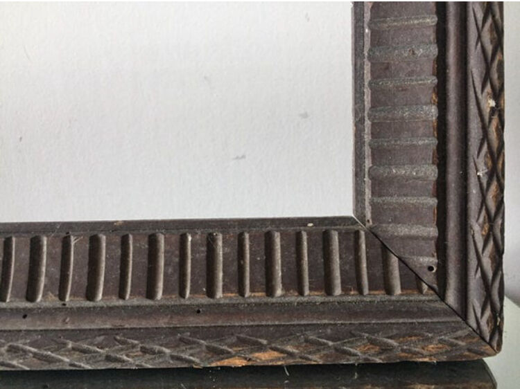 Antique wooden frame with geometric carvings light distress