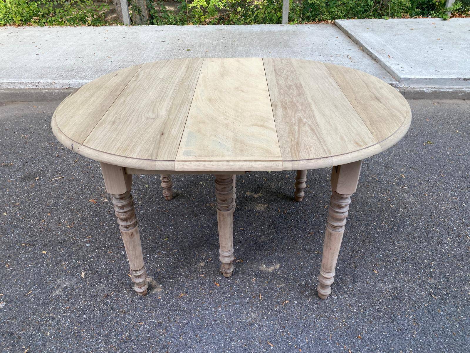 Round extendable dining table with flaps, stripped in raw oak, with 3 extensions.