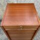 Vintage wooden filing cabinet with curtains.