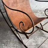 19th-century dark brown wrought-metal rocking chair with cognac leather sling seat, vintage