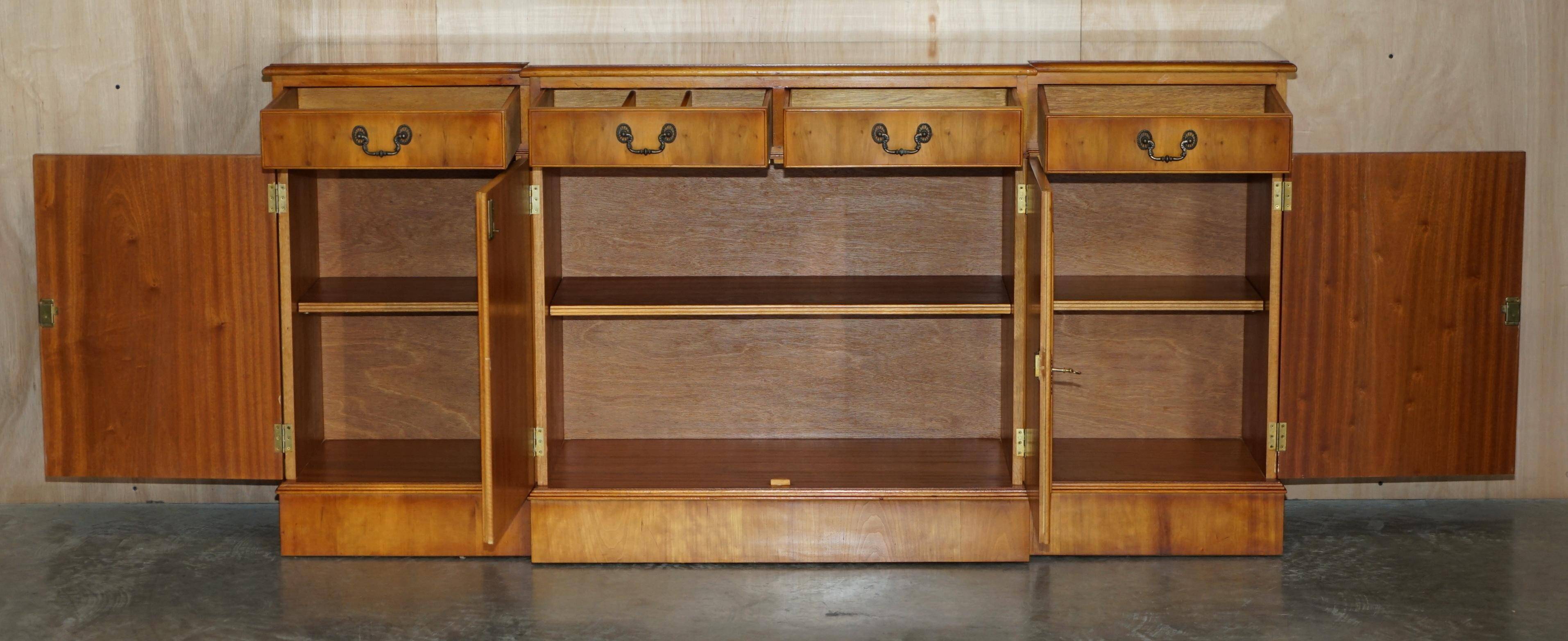 Vintage buffet made of mottled yew wood with three doors and four drawers.