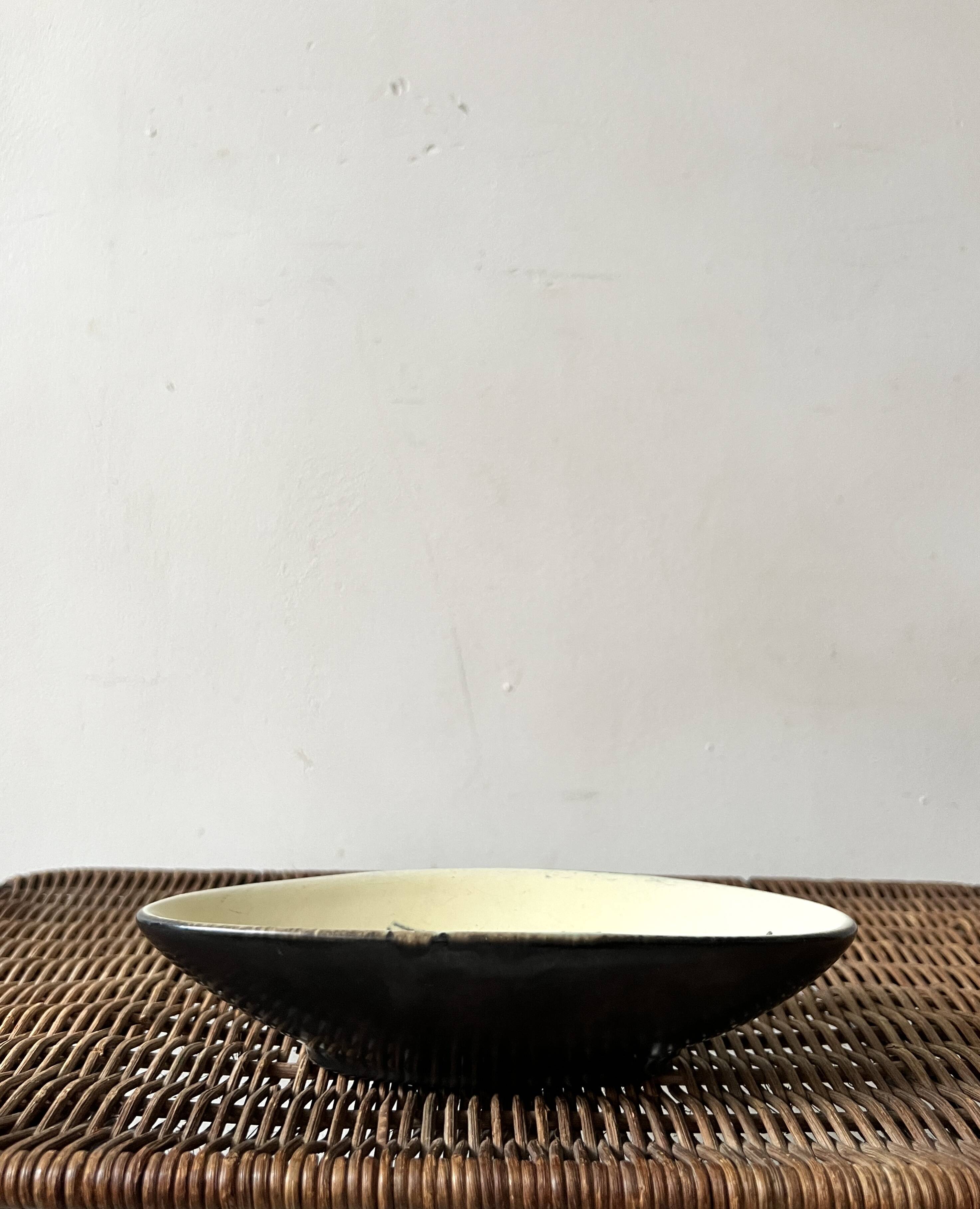 Pale yellow and black ceramic bowl / empty pocket signed by the artist