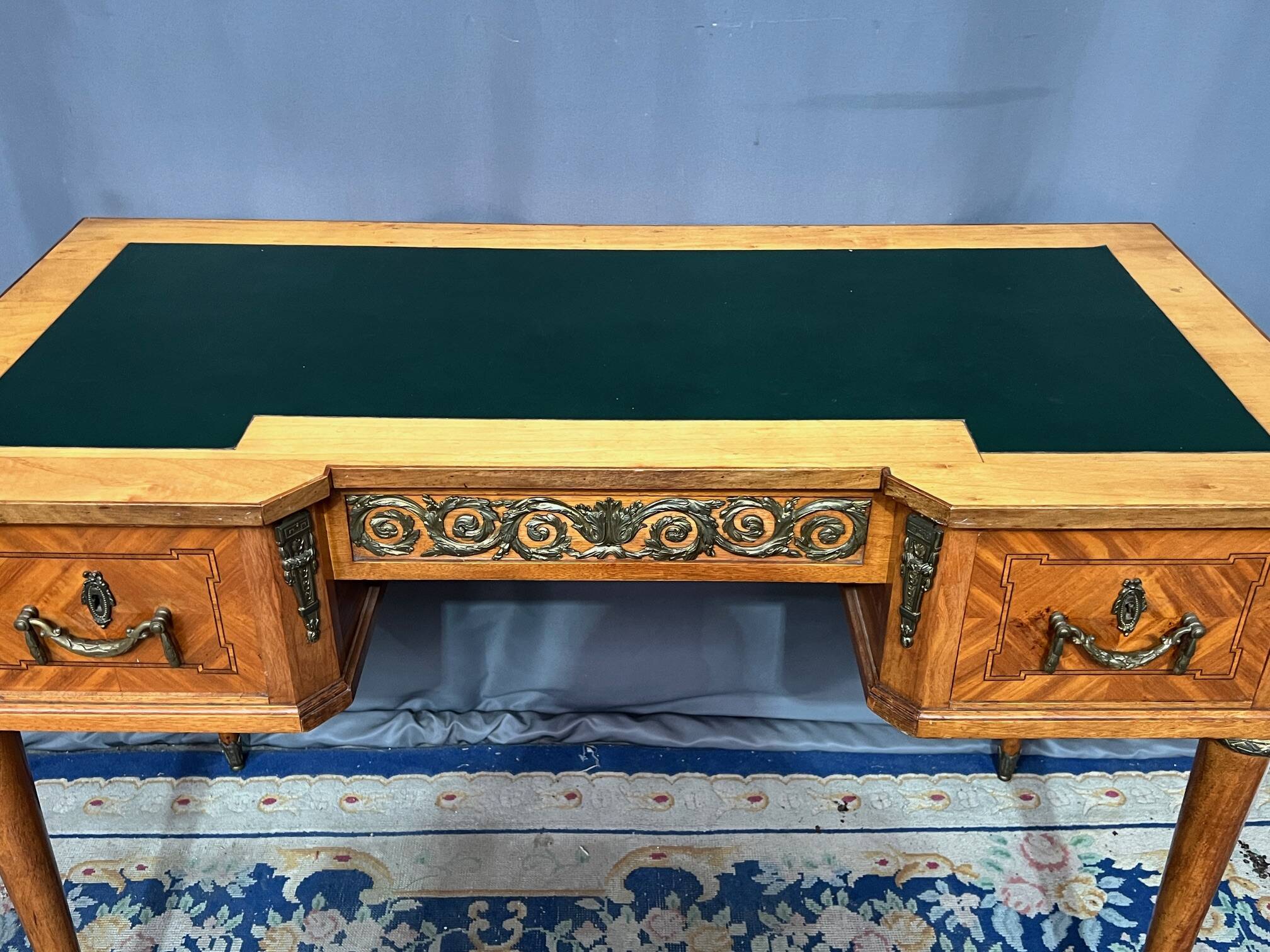 Louis XVI style marquetry desk. The top is decorated with green leather.