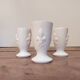 Three antique cups decorated with fleur-de-lis.