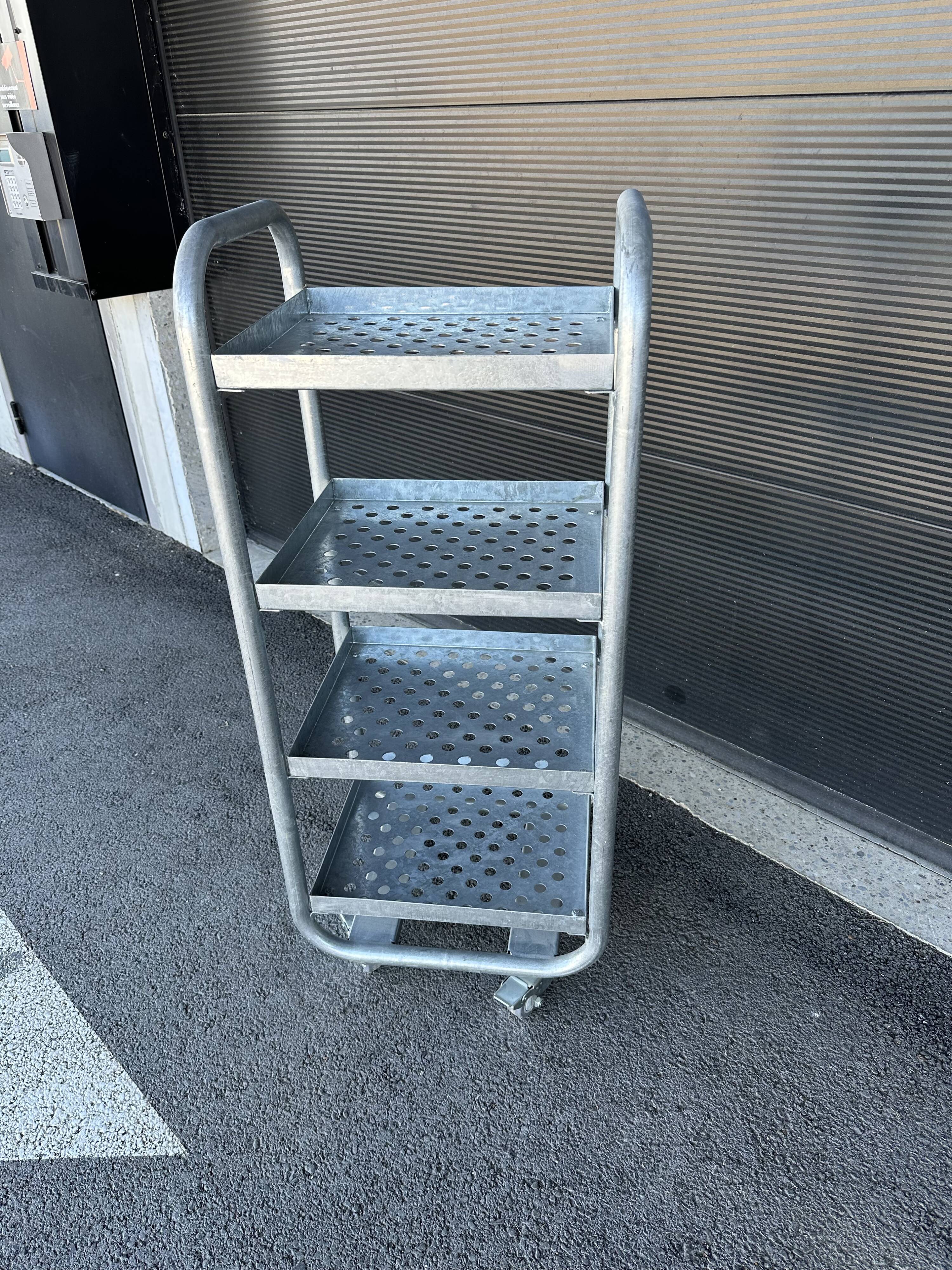 Four-wheeled dessert trolley with 4 perforated metal shelves.