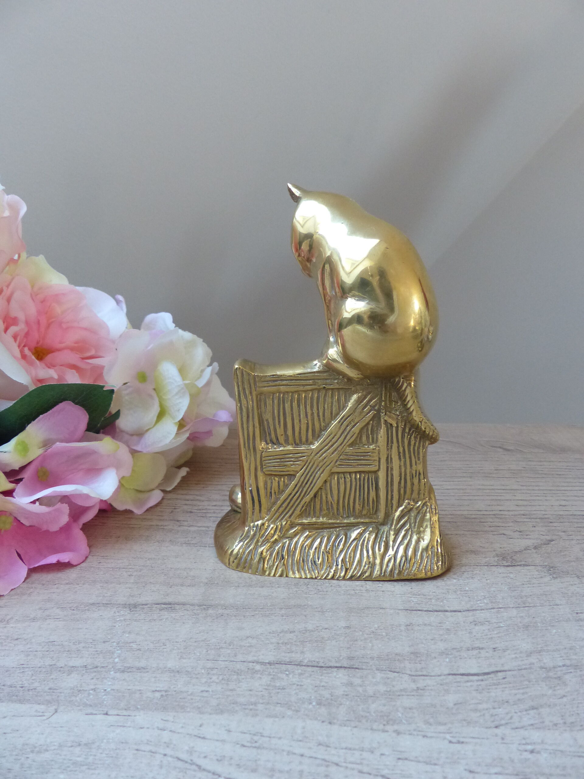 Golden brass cat figurine on fence looking at a mouse in a Vintage India shoe