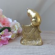 Golden brass cat figurine on fence looking at a mouse in a Vintage India shoe