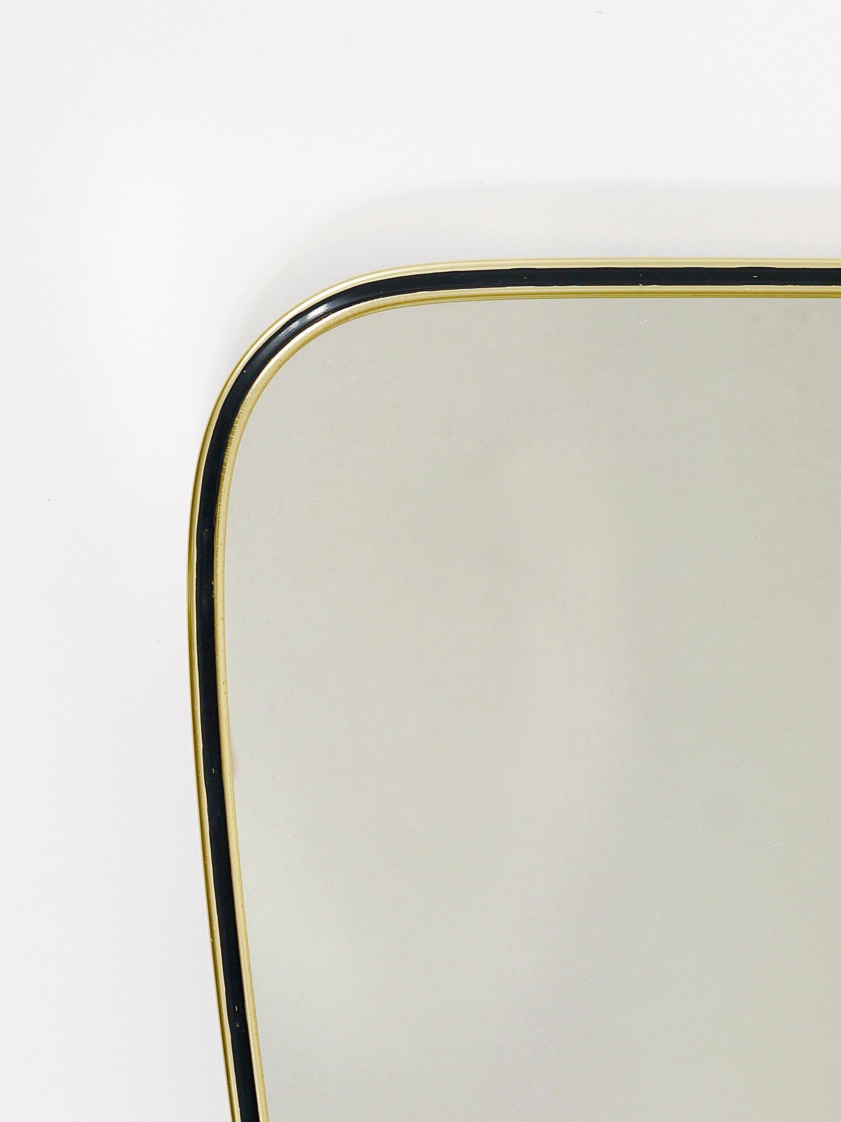 Elegant wall mirror in brass and black from the mid-century, Italy, 1950s.